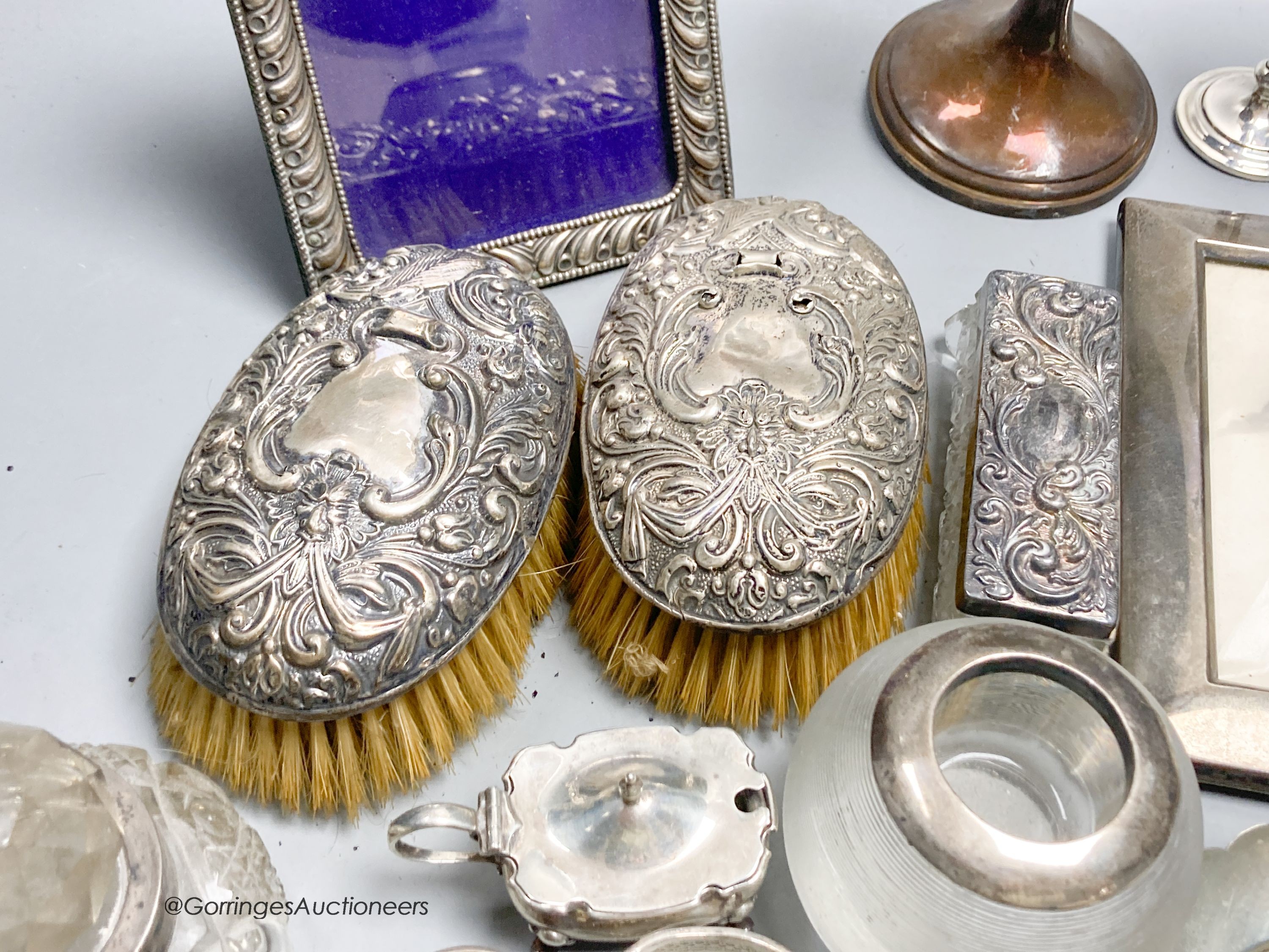 Sundry small silver including a trophy goblet, 22.5cm, napkin rings, two photograph frames, match tidy, spill vases, brushes, white metal tots and box etc.